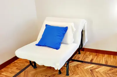 a white chair with a blue pillow on it at Casa Pan in Rome