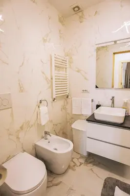 a white bathroom with a toilet and a sink at Casa Pan in Rome