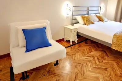 a room with two beds and a blue pillow on a chair at Casa Pan in Rome