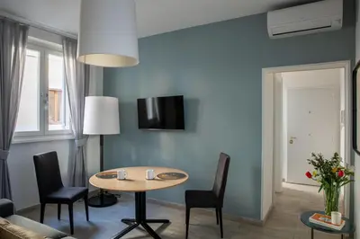 a living room with a table and chairs at Now Apartments, ApartHotel in the heart of Rome in Rome