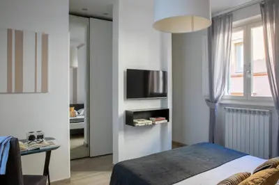 a bedroom with a bed and a tv and a window at Now Apartments, ApartHotel in the heart of Rome in Rome