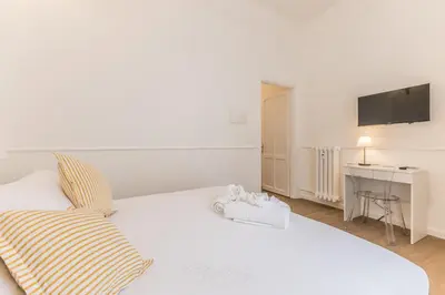 a bedroom with a large white bed and a desk at Elegant 3-bedroom apartment near the Metro in Rome
