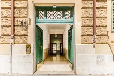 a hallway of a building with green doors at Elegant 3-bedroom apartment near the Metro in Rome