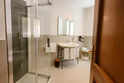 a bathroom with a glass shower and a sink at La Casa del Viaggiatore in Rome