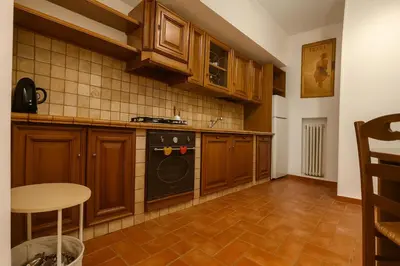 a kitchen with wooden cabinets and a black stove at La Casa del Viaggiatore in Rome