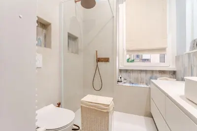 a white bathroom with a shower and a toilet at Refined two-bedrooms Roman Residence in Rome