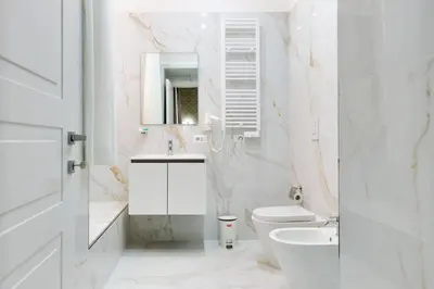 a white bathroom with a toilet and a sink at Il Rifugio del Re in Rome