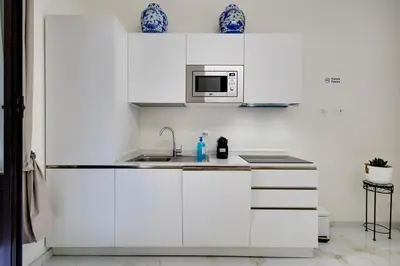 a white kitchen with a sink and a microwave at Il Rifugio del Re in Rome