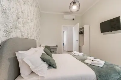 a bedroom with a bed and a tv on a wall at Elegant and spacious apartment facing the subway near the Vatican in Rome