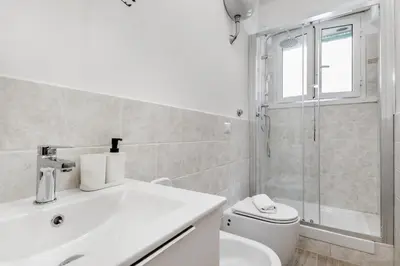 a bathroom with a sink and a toilet and a shower at Elegant and spacious apartment facing the subway near the Vatican in Rome