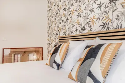 a bed with white sheets and pillows in a bedroom at Elegant and spacious apartment facing the subway near the Vatican in Rome