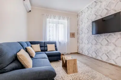 a living room with a blue couch and a tv at Elegant and spacious apartment facing the subway near the Vatican in Rome