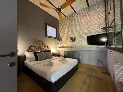 a bedroom with a large bed and a brick wall at Monti Penthouse in Rome