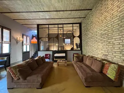 a living room with a couch and a brick wall at Monti Penthouse in Rome