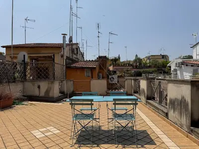 a patio with a table and chairs on a roof at Monti Penthouse in Rome