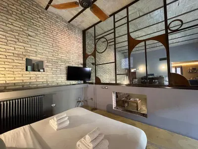 a room with a bed and a brick wall at Monti Penthouse in Rome