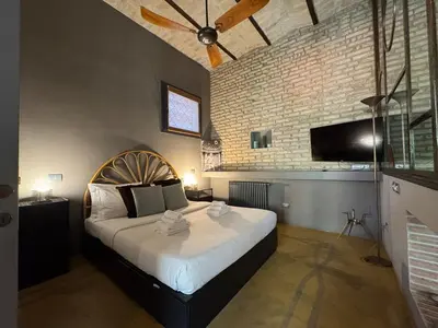 a bedroom with a large bed and a brick wall at Monti Penthouse in Rome