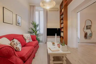 a living room with a red couch and a table at MyRentalInn - Vatican Prestigious Apartment in Rome