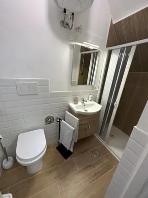 a white bathroom with a toilet and a sink at Home Delfini in Trastevere in Rome