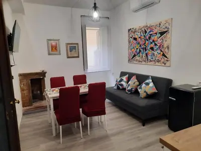 a living room with a couch and a table with chairs at Home Delfini in Trastevere in Rome