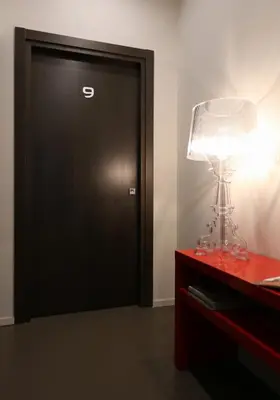 a room with a black door and a lamp on a dresser at Residenza Crescenzio in Rome