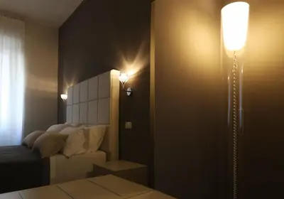 a bedroom with a bed and a light on the wall at Residenza Crescenzio in Rome