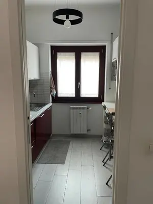 a kitchen with red cabinets and a stove top oven at Marta Cozy place near Vatican and subway in Rome