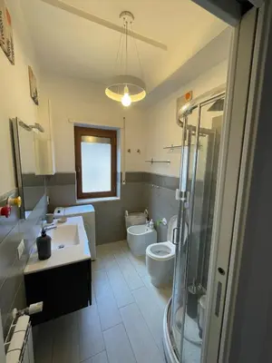 a bathroom with a shower and a sign that reads home is where the heart is at Marta Cozy place near Vatican and subway in Rome
