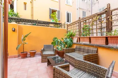 a patio with chairs and tables on a balcony at Easybnb - Daisy in Rome