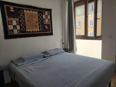 a bed in a bedroom with a picture on the wall at Tanner's Apartment - Piramide in Rome