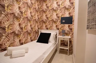 a small bedroom with a bed and a wall with feathers at Pantheon Luxury Apartment in Rome