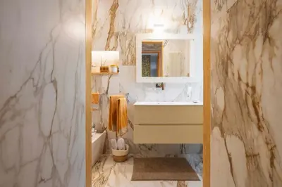 a marble bathroom with a sink and a mirror at Orange Tree Home in Rome