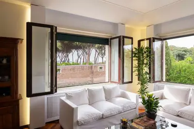 a living room with a white couch and two windows at Orange Tree Home in Rome