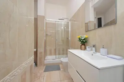 a bathroom with a white sink and a shower at Interno 5 elegante residenza per 10 pax vicina a Colosseo e Santa Maria Maggiore in Rome