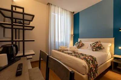 a bedroom with a bed and a desk with a computer at New Roman Experience in Rome