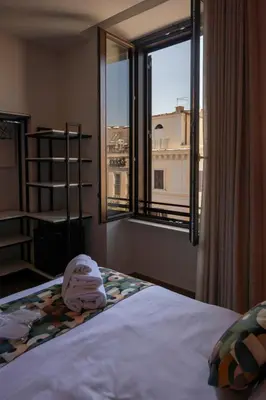 a bedroom with a bed and a large window at New Roman Experience in Rome