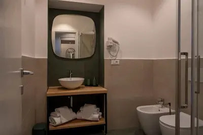 a bathroom with a sink and a toilet and a mirror at New Roman Experience in Rome