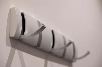 a white object with black handles on a wall at New Roman Experience in Rome