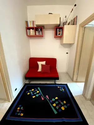 a living room with a red couch and a rug at Small and very small house in Rome