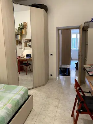 a bedroom with a bed and a room with a table at Small and very small house in Rome