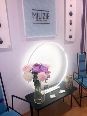 a vase of flowers on a table in front of a mirror at Milizie 76 Gallery in Rome