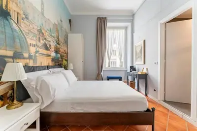 a bedroom with a large white bed with a painting on the wall at Fori Imperiali Colosseum in Rome