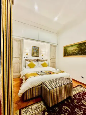 a bedroom with a large white bed with a bench next to it at Fori Imperiali Colosseum in Rome