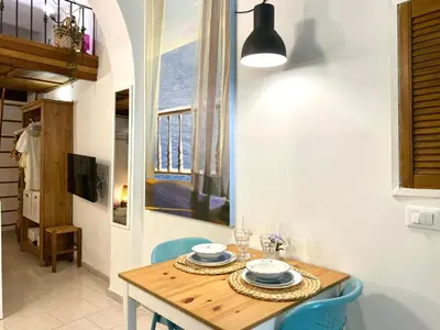 a dining room with a table and chairs and a window at Trastevere Loft Leopardo in Rome