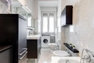 a bathroom with a toilet sink and a washing machine at L'oasi romana di Daniela in Rome