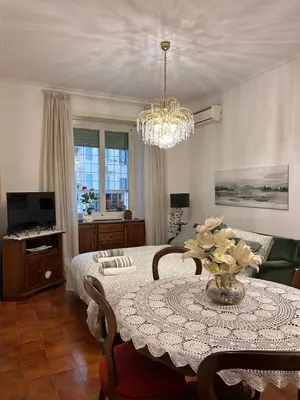 a living room with a table and a chandelier at A casa di Tony in Rome