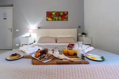 a breakfast tray on a bed with food on it at Bella Roma Luxury Accommodation, Vatican City - Liberty Collection in Rome