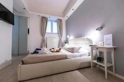 a bedroom with a white bed and a table at Bella Roma Luxury Accommodation, Vatican City - Liberty Collection in Rome