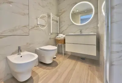a bathroom with a toilet and a sink and a mirror at Casa Colli in Rome