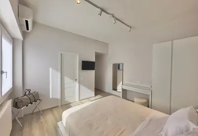 a white bedroom with a large bed and a window at Casa Colli in Rome